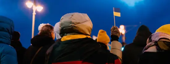 Woman holding a small Ukranian flag in the cold