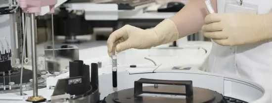 Person putting test tube in medical device