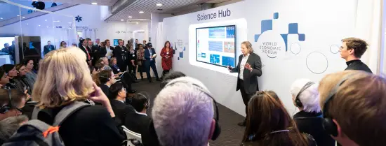 A group of people around a smartboard with 'science hub' above it.