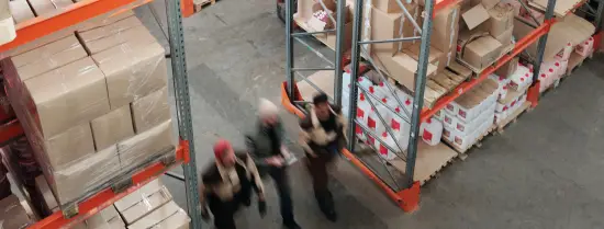 Inside of a warehouse with people walking 