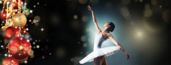 Ballet danseres die een pose vasthoudt en kerstballen