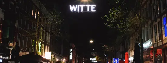 Nachtfoto van een drukke Witte de Withstraat in Rotterdam.