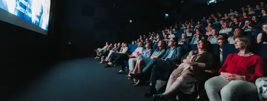 Een volle bioscoopzaal bekijken de lustrumdocumentaire '110 jaar in 010'.