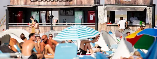 Zonnende mensen bij de horeca op het strand van Hoek van Holland.