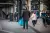 Een man loopt rond met een Albert Heijn tas bij een tramhalte.